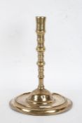 17th Century brass candlestick, circa 1660, the flared sconce above a knopped stem and dished