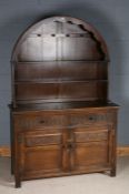 17th century style oak dresser and rack, with an arched rack above the cupboard base with thumb