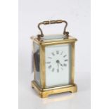 French brass cased carriage clock, the white enamel dial with black roman numerals, visible platform