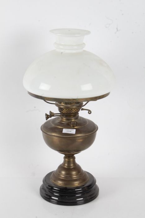 20th century brass oil lamp with a opaque white glass shade above a brass reservoir, 49cm high