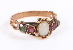 A yellow metal and opal ring, the head set with a oval opal with garnets and emeralds to the