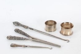 Two silver handled button hooks, pair of silver handled glove stretchers, two silver napkin rings,