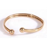 9 carat gold bangle with orb form ends, 7 grams
