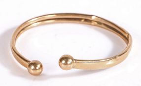 9 carat gold bangle with orb form ends, 7 grams