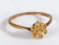 A yellow metal ring with a flower shaped head set two pearls, ring size M weight 1.3 grams