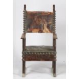 An Italian Baroque oak armchair, the leather pad back flanked by acanthus leaf tips above the