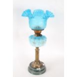 A Victorian oil lamp, with a blue ceramic base with a reeded brass stem above a pale blue and gilt