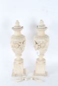 Pair of Alabaster urns, each with leaf and flower decoration, raised on square plinth bases, 45cm