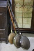 Three copper and brass warming pans, one with an embossed lid all with wooden handles (3)