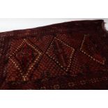 An Afghanistan mushwani style prayer rug, with a red and orange ground, three diamond guls with a