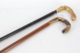 Two horn handled waking canes, one with ebonised shaft (2)