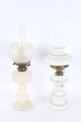 Two Victorian opaque glass oil lamps, the first with blue and gilt bands, the other of plain form (