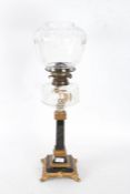 A Victorian oil lamp, with a ormolu and marble base and stem with a clear glass reservoir and shade,