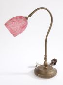 Brass reading lamp, with mottled puce and white glass shade mounted to a curved arm and circular