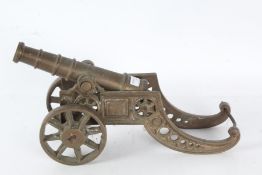 A large brass signalling or desk cannon, the barrel is 28cm long raised on a pierced body with two