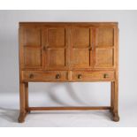 Cotswold School style Arts and Crafts oak cabinet, the four panelled cupboard doors opening to