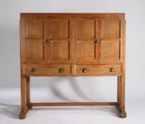 Cotswold School style Arts and Crafts oak cabinet, the four panelled cupboard doors opening to