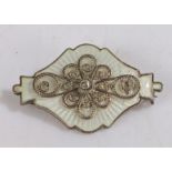 Ivar T. Holth Norwegian silver and white enamel brooch, with central scrolled filigree decoration,