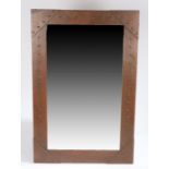 Arts & Crafts copper framed wall mirror, the frame with beaten and riveted decoration, 48cm x 75cm