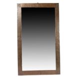 Arts & Crafts copper framed mirror, the beaten frame with fleur de lys and rose decoration
