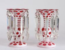 Pair of Victorian candle lustres, the ruby glass bodies overlaid in white with slice cut roundel