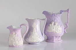 Three early to mid 19th Century lilac relief moulded jugs, the first by Samuel Alcock depicting