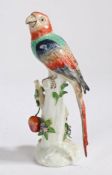 A Sampson Chelsea style porcelain parrot, the polychrome parrot standing on a branch with hanging