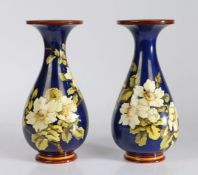 Pair of Doulton Lambeth Faience vases, the blue ground decorated with white roses, stamped to