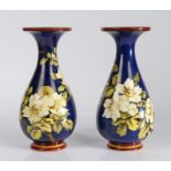 Pair of Doulton Lambeth Faience vases, the blue ground decorated with white roses, stamped to