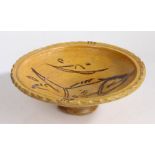 An unusual pottery slipware decorated dish, the wide high rimmed dish with a central fish design,