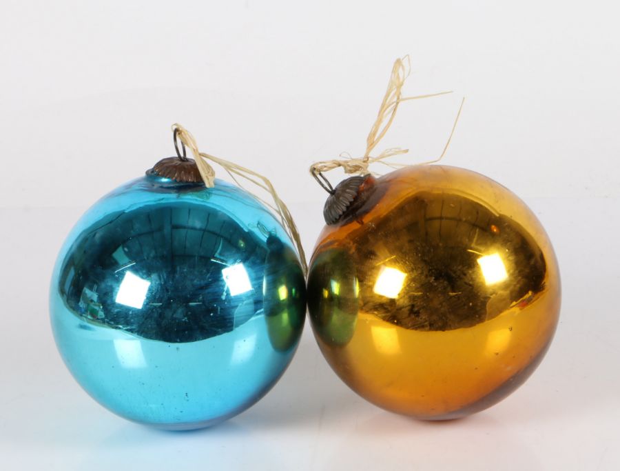 Two glass witches balls, one mirrored blue, one mirrored gold, both with metal hanging mounts,