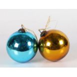 Two glass witches balls, one mirrored blue, one mirrored gold, both with metal hanging mounts,