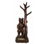 A Folk Art carved standing bear stick stand, the bear with wide eyes and an pen mouth holding onto a