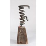 A primitive 19th Century iron and oak spiral candlestick, the spiral body with internal candle