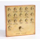 An unusual and large brass fronted School of Art sixteen button multiple bell push board, with a '