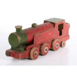 An early 20th century painted wooden toy locomotive, in red & green, eight wheels, 41cm long.