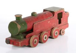 An early 20th century painted wooden toy locomotive, in red & green, eight wheels, 41cm long.