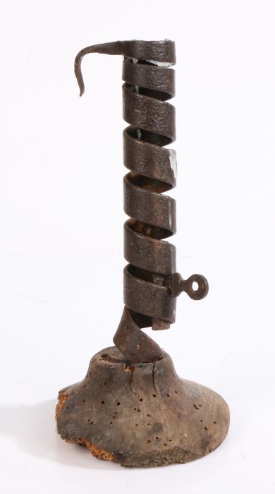 An 18th century wrought iron spiral candlestick, rudimentary ejector, softwood base a/f, 19cm high.