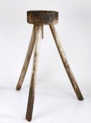 A 19th century wooden chopping block, cylindrical top raised on three faceted supports, 76cm high.