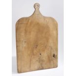 A 19th century wooden dough-board, of large proportions, single pierced handle, 86cm long.