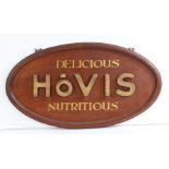 Mid 20th Century wooden Hovis bread shop advertising sign, the oval signed with gilt lettering and