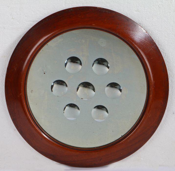 A Victorian sorcerer's mirror, circular form with seven central convex roundels, mahogany frame,