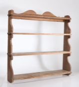 A set of Victorian painted wooden wall-hanging shelves, four graduated tiers, shaped scrollwork