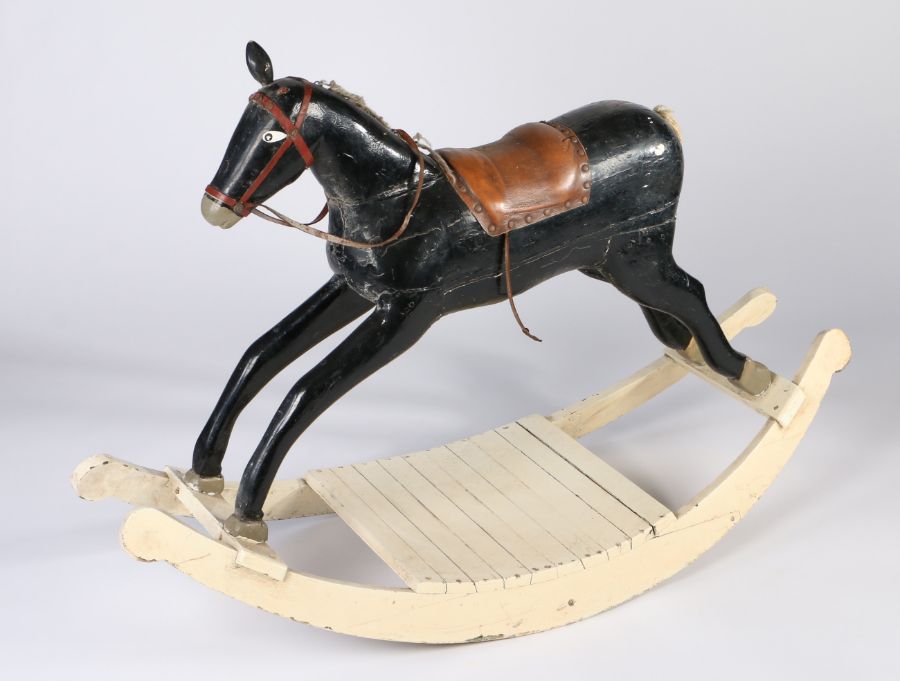 An early 20th century painted wooden rocking horse, later leather saddle, wool mane & tail, 88cm