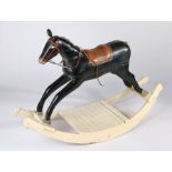 An early 20th century painted wooden rocking horse, later leather saddle, wool mane & tail, 88cm