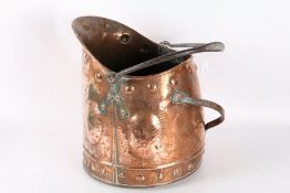 Arts and Crafts copper spot hammered coal scuttle, with iron handles, the body with roundel