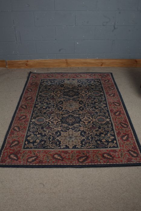 A 20th century middle eastern style rug, the blue and red ground with five main floral medallions