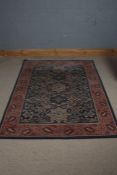 A 20th century middle eastern style rug, the blue and red ground with five main floral medallions