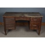 A 20th century oak desk the rectangular top above a tambour shutter enclosing letter trays, together