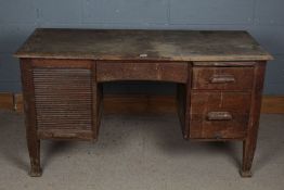 A 20th century oak desk the rectangular top above a tambour shutter enclosing letter trays, together